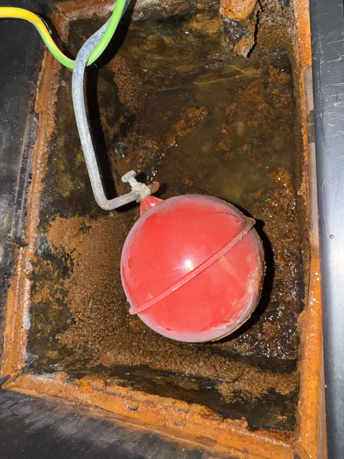 Feed and expansion header tank full of rust and sludge before cleaning